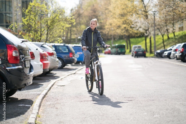 Obraz woman commuting on bicycle and looking at camera