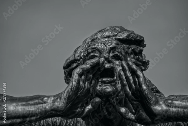 Obraz Statue with a gesture of call. Head of sculpture with open mouth and hands. Background of pure sky. Black and white photo.