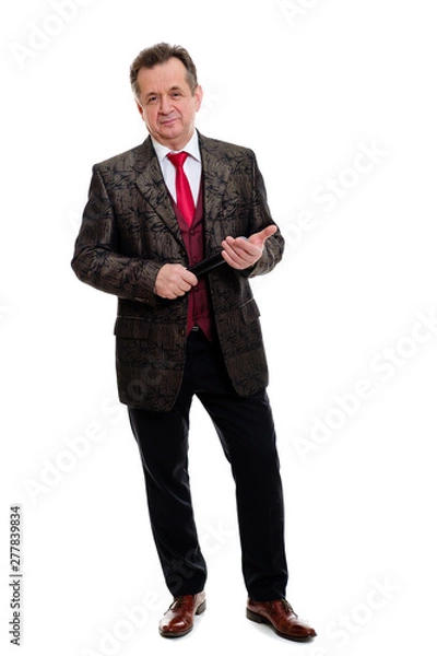 Fototapeta Full length portrait of happy and successful senior man 60-65 years old. Businessman senior stand in beautiful suit with red tie and white shirt. Grinning Man hold microphone. Isolated on white