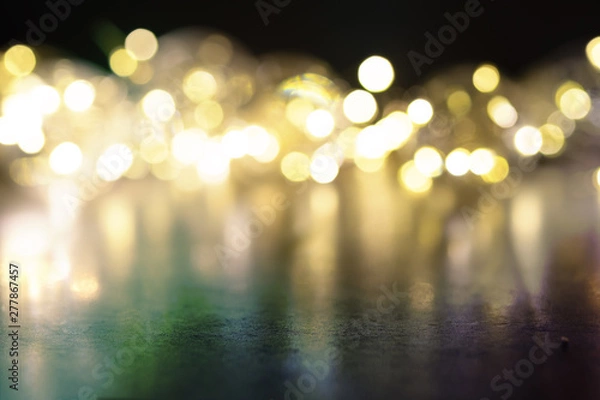 Fototapeta Garland of light bulbs on a black background. Place for text.