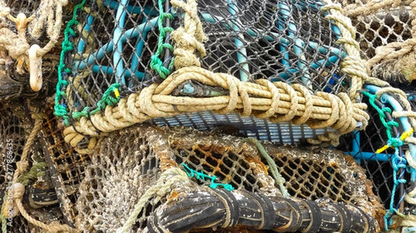 Fototapeta Close up of stacked commercial fishing lobster pots. With ropework netting knots and ties. Empty, showing signs of regular use. Landscape image with space for copy. Cornwall.