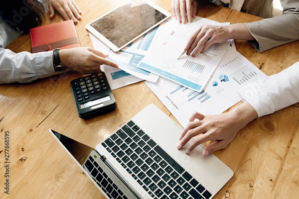 Obraz business meeting, business woman Explain analyze the company's sales plan to team leader and business owner by use computer laptop, calculator, stock maket chart on wood desk in conferance..