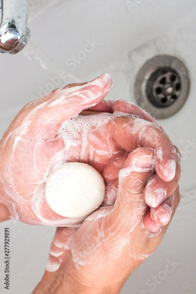 Obraz The hands of a man who washes his hands with soap dispenser.