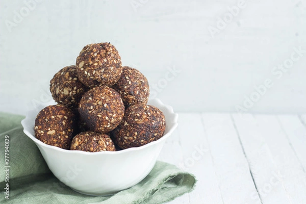 Obraz appetizing energy balls in a  white bowl white wooden background