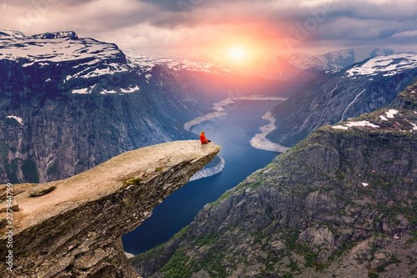 Obraz Norwegia, Kobieta siedzi na zboczu góry Trolltunga