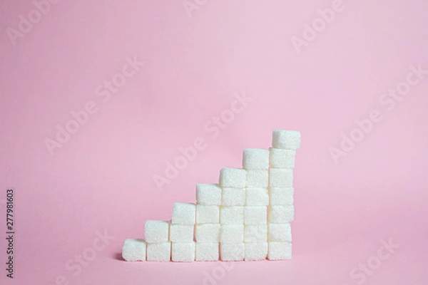 Fototapeta Stack the sugar cubes from ascending to pink background - the concept of high blood sugar risk.