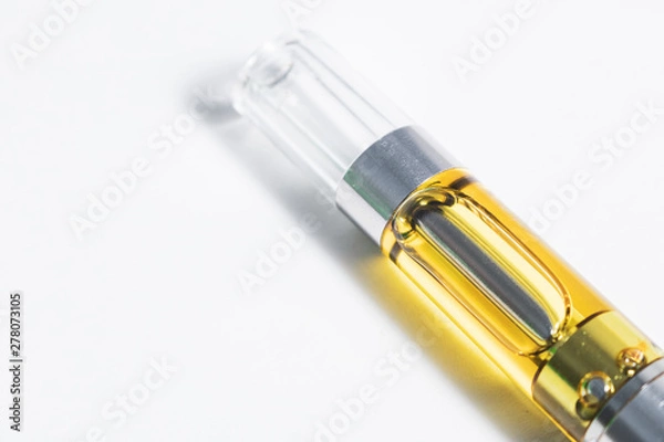 Obraz Cannabis oil liquid extract up-close in plastic cartridge, to vape and inhale the medicinal cannabinoids THC & CBD found in marijuana plants. Object isolated on white background