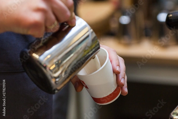 Fototapeta Making a barista from a cafe latte art, close-up of the hands of a man heating the milk in a coffee machine.