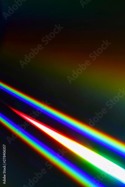 Fototapeta Beams of light refracting and creating a rainbow spectrum of colours against a black background