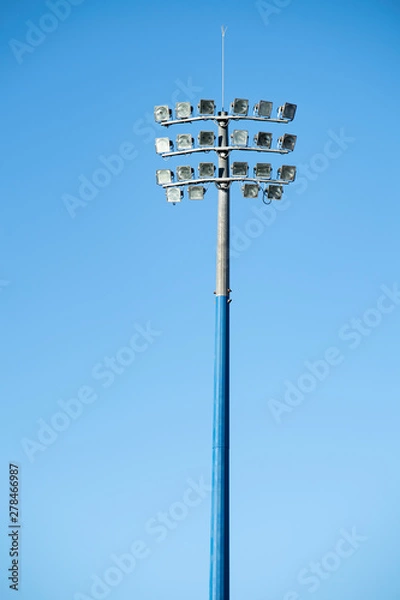 Obraz Sports stadium light tower during the day, set against a blue sky.