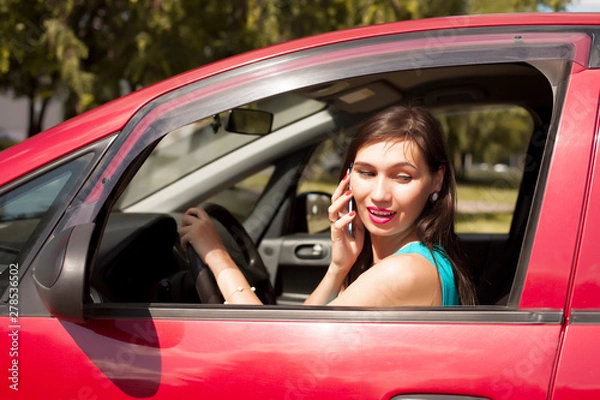 Fototapeta Driver woman driving a car distracted on the phone