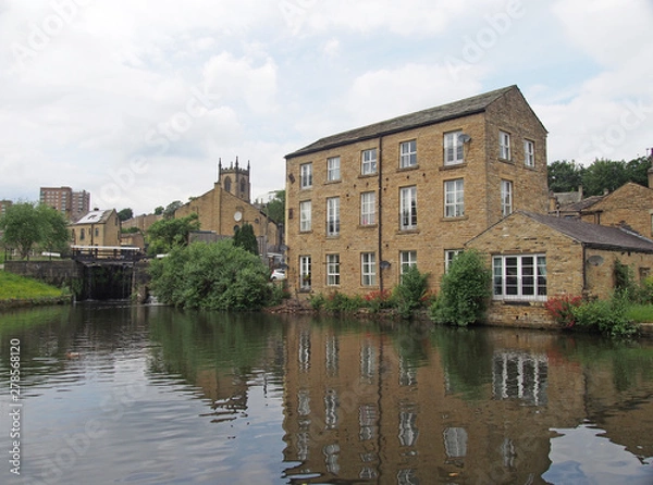 Obraz a scenic view of the town of sowerby bridge in west yorkshire with buildings reflected in the canal basin and buildings behingd the lock gates