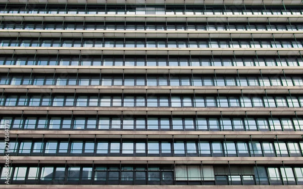 Fototapeta the facade of a office building with many windows arranged in a line,