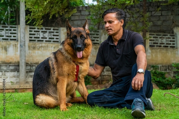 Obraz German Shepherd with Handler in Garden