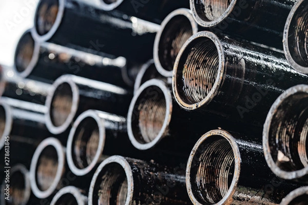 Fototapeta Drilling of oil and gas wells. Drill pipe inspection. Tubing for oil and gas listed on the pedestal out of the wells after washing and ready for inspection. Stack of casing laying on the deck.