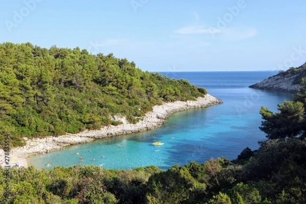 Fototapeta An overhead view of Zitna Beach, on a wonderfully spectacular bay nestled next to the little sea edge town of Zavalatica on Korcula Island in Croatia.  The water is a beautiful turqvoise colour.