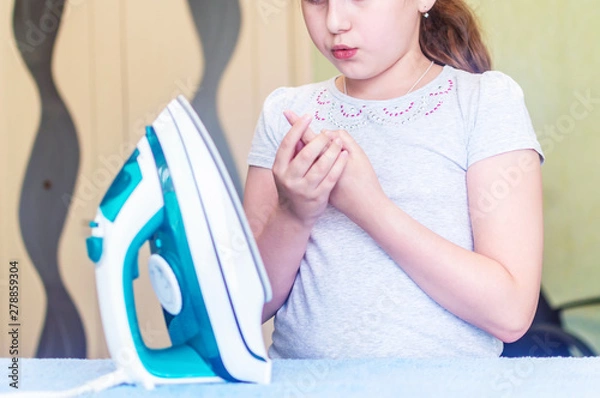 Obraz the girl received a burn when Ironing clothes on the Ironing Board with an iron