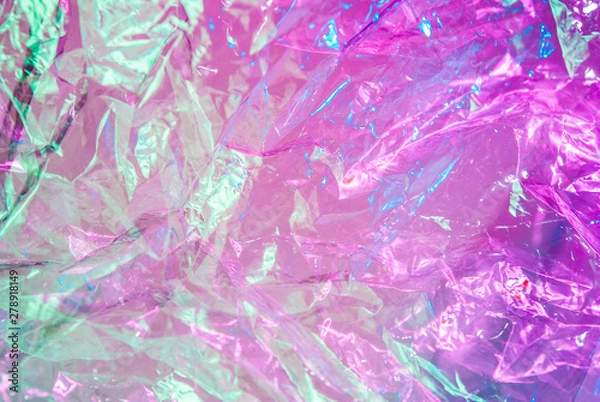 Fototapeta Holographic background in the style of the 80-90s. Real texture of cellophane film in bright acid colors.