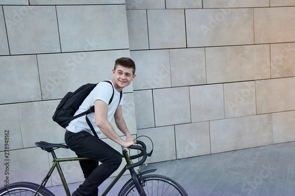 Fototapeta Handsome hipster man posing with bicycle in the city.