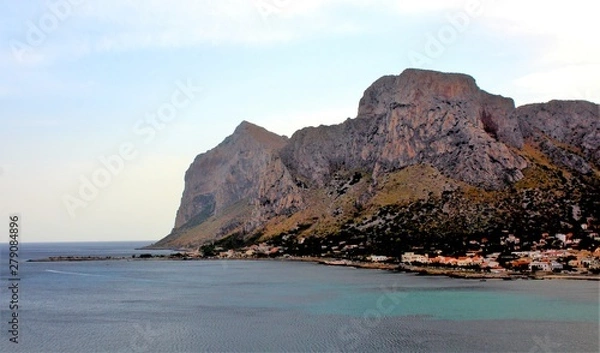 Fototapeta evocative image of maritime coast at sunset with fishing village in the background in Sicily, Italy