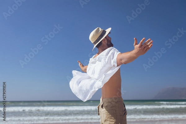 Fototapeta Happy man standing with open arm at beach
