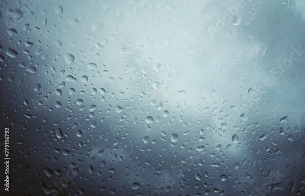 Fototapeta A windshield filled with rain drops in an overcast sky.