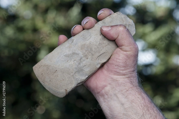 Obraz filthy hand holding handaxe