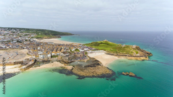 Obraz Aerial view of picturesque seaside town of St Ives with sandy beaches by turquoise sea, small fishing port, fortified headland,  in Cornwall , south east England on a cloudy summer day .