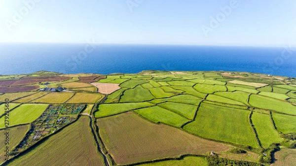Obraz Aerial view of green, ploughed farm fields mosaic by Atlantic Ocean on the Cornish coast, on a summer clear day .