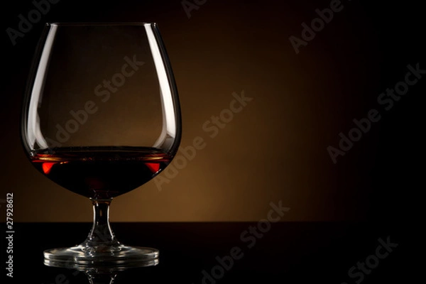 Obraz Glass of brandy over brown background