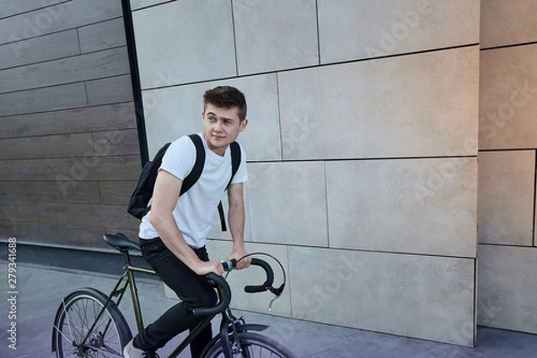 Fototapeta Handsome hipster man posing with bicycle in the city.