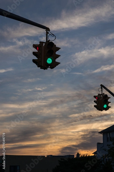 Fototapeta Traffic light with red light against the evening sky in USA.  Selective focus.
