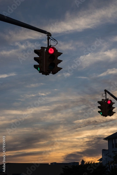 Fototapeta Traffic light with red light against the evening sky in USA.  Selective focus.