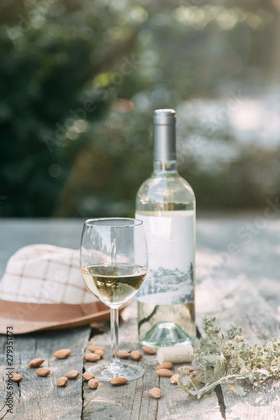 Fototapeta Bruschettes and a picnic with prosciutto. White wine with a glass in nature in Italy.