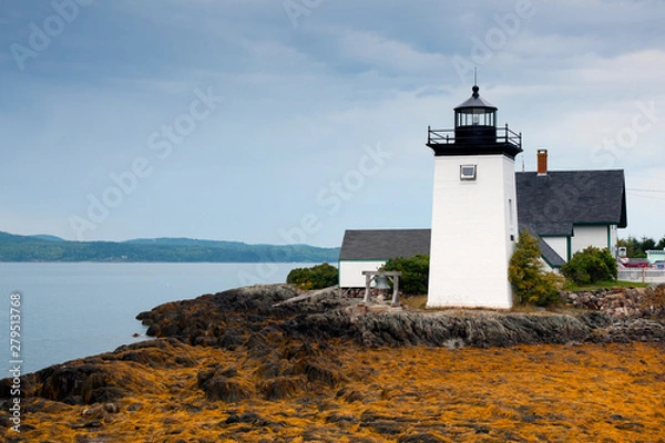Fototapeta Sun Breaks Through Clouds Illuminates Maine Lighthouse at Low Tide in Maine