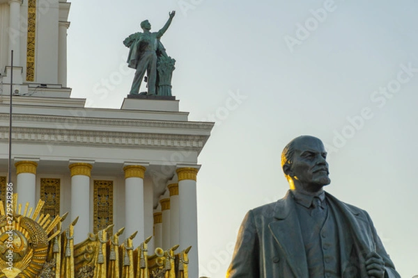 Fototapeta Soviet communist leader Vladimir Lenin statue in front of old building at VDNH in Moscow