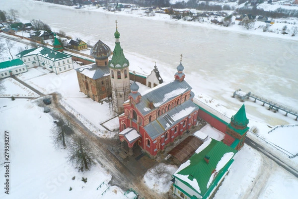 Fototapeta Over the ancient temples of the Old Ladoga Nikolsky Monastery on an overcast February day (filming from a quadcopter). Staraya Ladoga, Russia