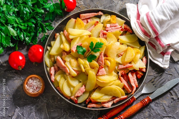 Obraz Fried potatoes with meat in a pan on the background of the stone. Quick lunch or dinner from potatoes.