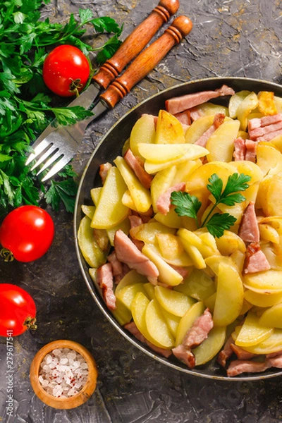 Obraz Fried potatoes with meat in a pan on the background of the stone. Quick lunch or dinner from potatoes.