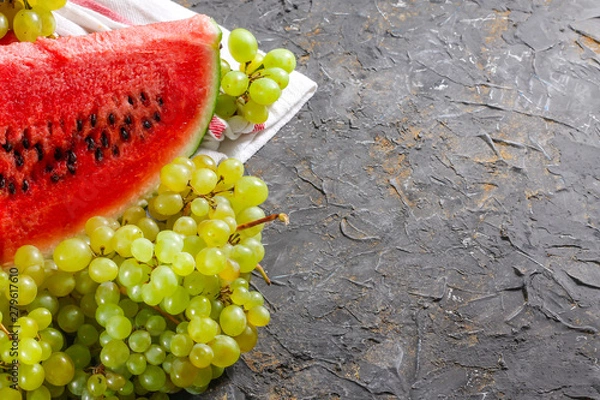 Obraz Watermelon and grapes on a stone background. Autumn harvest.