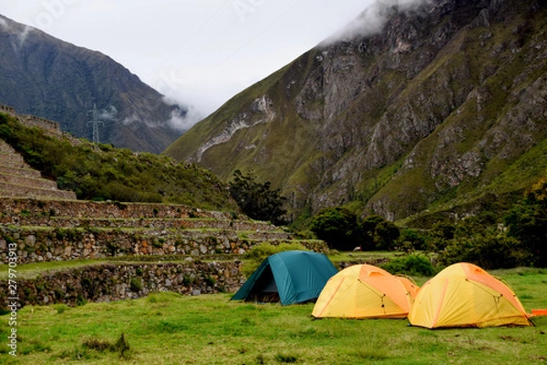 Fototapeta Camping in the mountains on a cloudy day with tents next to old ruins on the Inca trail to Machu Picchu in Peru
