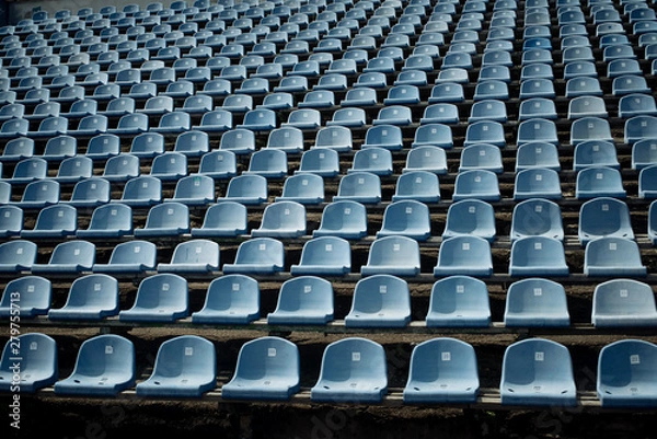 Fototapeta Rows of blue empty seats in the stand in the sports arena.