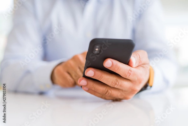 Fototapeta Close up of business man hands using smarpthone