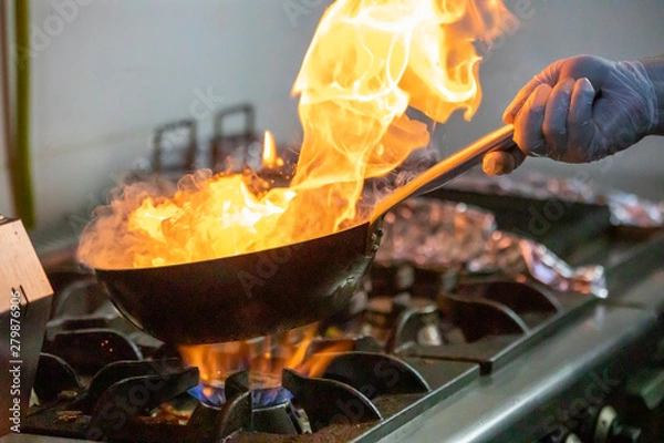 Fototapeta Chef doing flambe on food