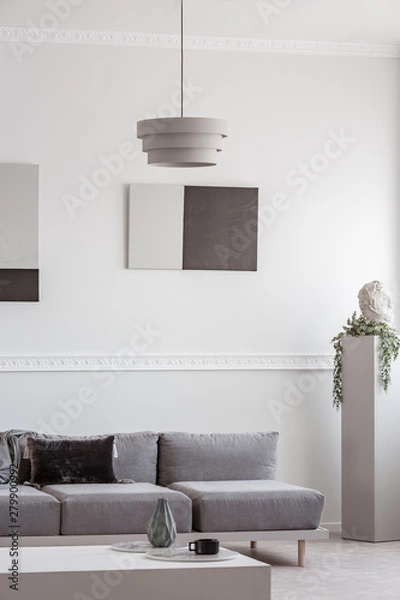 Obraz Grey sofa in white interior with abstract paintings on the wall