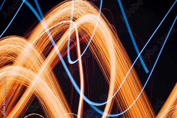 Fototapeta Colorful pattern of orange and blue dynamic lines of light. Art concept of lighting effects. Trendy background for your design.