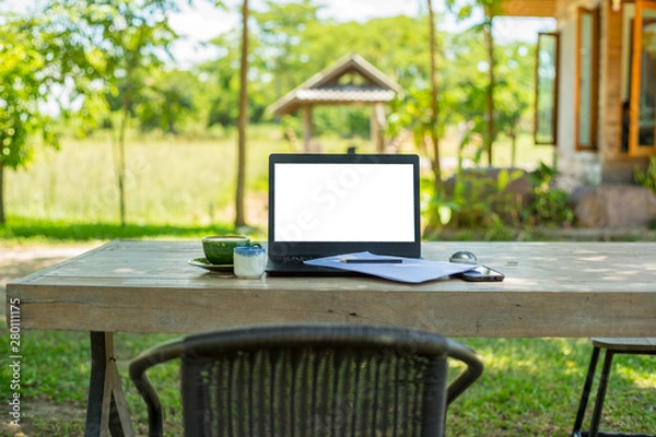 Fototapeta enjoy coffee relaxing and work on a laptop in balcony garden green trees background in the holiday