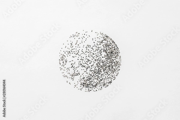 Fototapeta Abstract composition, silver glitter scattered in the form of a circle on a white paper background and create the illusion of a sphere.