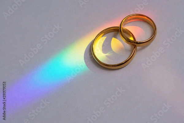 Obraz Two wedding rings with rainbow.