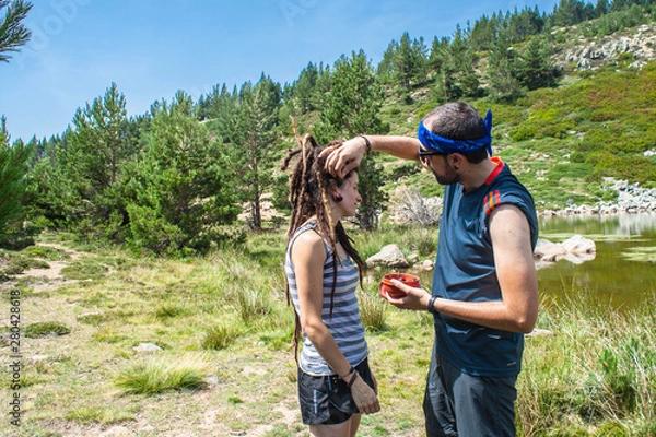 Fototapeta man and woman eat cherries on the mountain